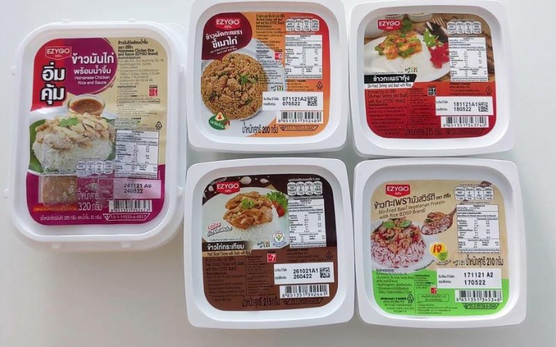 Boîtes-repas de riz instantané de la marque EZYGO vendues chez 7-Eleven en Thaïlande, avec différentes recettes comme poulet à la sauce, basilic sauté ou version végétarienne