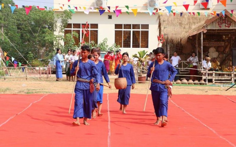 Jeunes interprètes khmers en tenue bleue traditionnelle marchant pieds nus lors d’une représentation culturelle pendant les festivités du Nouvel An cambodgien, Chol Chnam Thmay