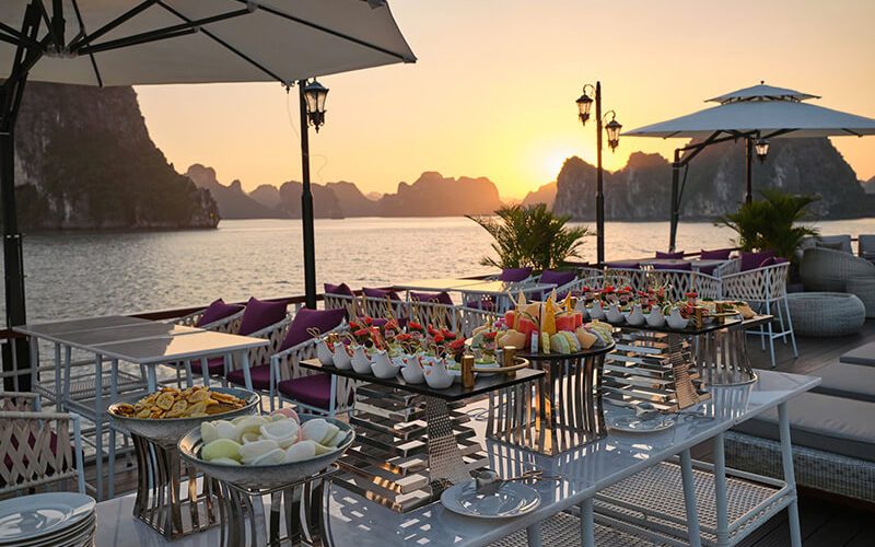 Dîner romantique au coucher du soleil à bord d’une croisière de luxe dans la baie d’Halong, avec vue sur les formations karstiques emblématiques du Vietnam