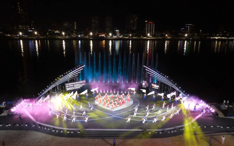 Spectacle d’ouverture vibrant du Festival International de Feux d’Artifice de Da Nang, mettant en scène des danseurs costumés sur une scène illuminée au bord de la rivière Hàn