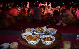 Dîner traditionnel Kantoke à Chiang Mai, avec des plats thaïlandais servis dans des bols en porcelaine, accompagné d'un spectacle de danse et de musique traditionnelle