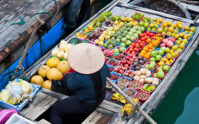 Étal coloré de fruits tropicaux sur un bateau au marché flottant du delta du Mékong, une scène authentique de la vie fluviale vietnamienne