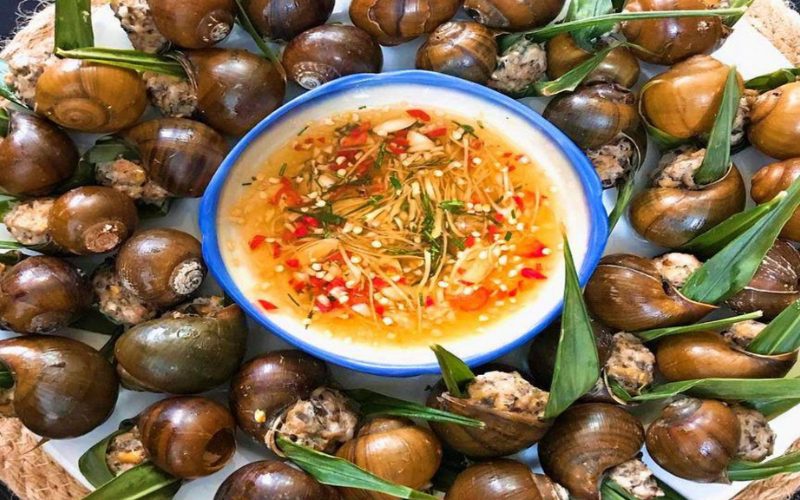 Plat traditionnel d’escargots farcis à la viande et aux herbes, servis avec une sauce nuoc-mâm aigre-douce au piment, ail et gingembre, spécialité de Vinh Long