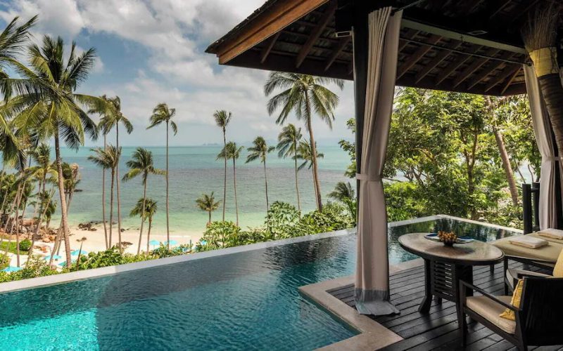 Villa de luxe en bord de mer en Thaïlande avec piscine à débordement, palmiers tropicaux et vue panoramique sur l’océan