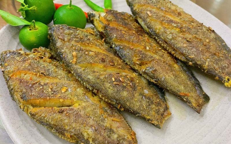 Assiette de poissons gourami géants frits croustillants, spécialité de Vinh Long, accompagnés de petits citrons verts et de piments frais