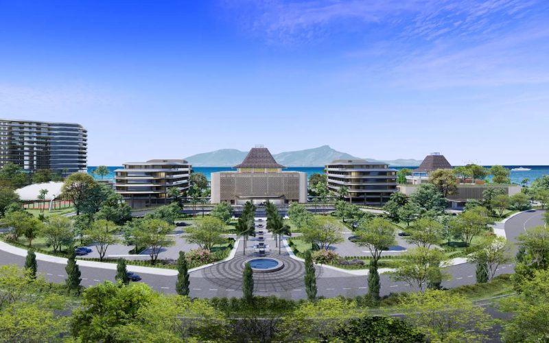 Vue d’ensemble d’un complexe hôtelier moderne en bord de mer, avec bâtiments contemporains, jardins paysagers et vue sur l’océan et les montagnes en arrière-plan