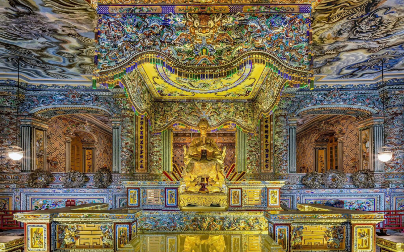 Intérieur somptueusement décoré du mausolée de Khai Dinh à Hué, Vietnam, avec sa statue dorée de l’empereur et ses ornements en mosaïque colorée d’une grande finesse artistique. Le tombeau de Khai Dinh est connu comme l'un des plus beaux tombeaux impériaux de Hué.