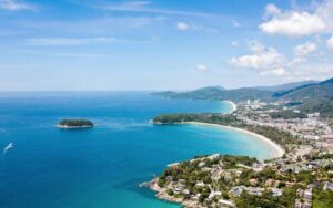 Vue aérienne de Kata Beach à Phuket, avec ses eaux turquoise, son sable blanc et ses collines verdoyantes en arrière-plan