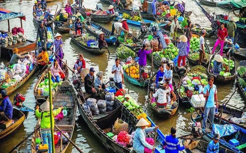 Les bateaux au marché flottant de Cai Be sont empilés avec des fruits colorés et d'autres aliments