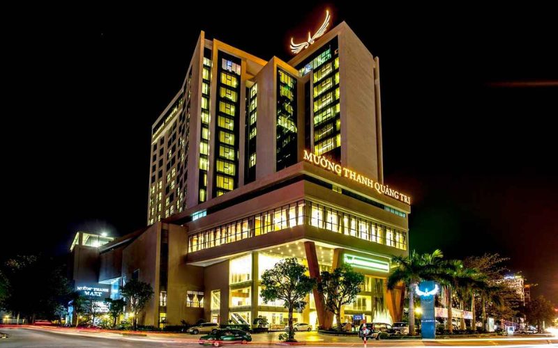 Façade illuminée de l’hôtel Muong Thanh Quang Tri la nuit, un hôtel moderne 4 étoiles situé au cœur de la ville de Dong Ha