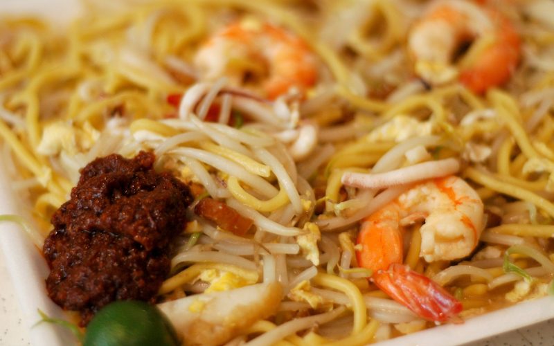 Assiette de Mee Hokkien, un plat de nouilles sautées de Phuket avec crevettes, pousses de soja, œuf et sauce pimentée