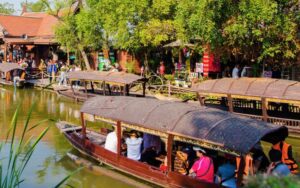 Vue animée du marché flottant d'Ayutthaya avec des visiteurs à bord de bateaux traditionnels en bois naviguant le long des canaux