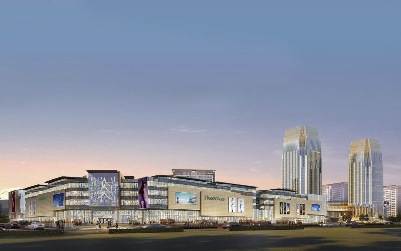 Centre commercial moderne Parkson illuminé au crépuscule, avec une architecture élégante en verre et en acier, entouré de gratte-ciel imposants et de passants animant l’entrée principale
