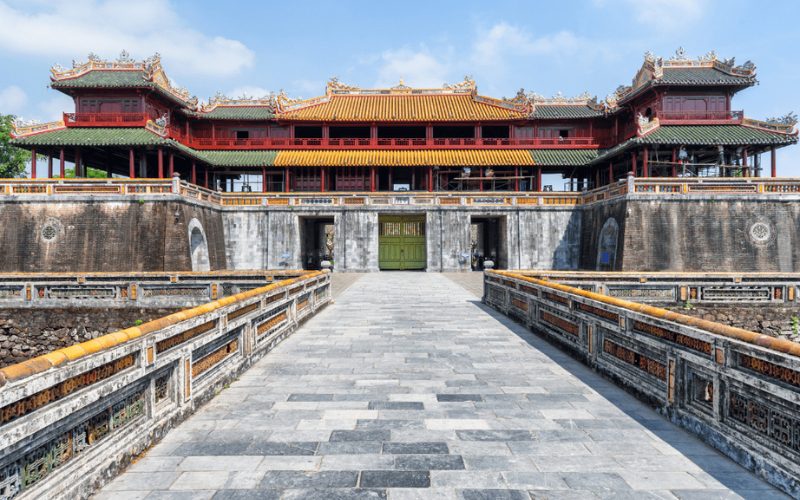Vue frontale de la porte Ngo Mon, entrée principale de la Cité impériale de Hué, avec son architecture traditionnelle vietnamienne, ses toits en tuiles vernissées colorées et son pont de pierre traversant les douves