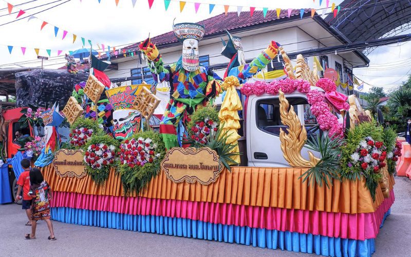 Char coloré décoré de fleurs, de masques Phi Ta Khon et d’ornements traditionnels défilant dans les rues lors du festival des fantômes à Dan Sai