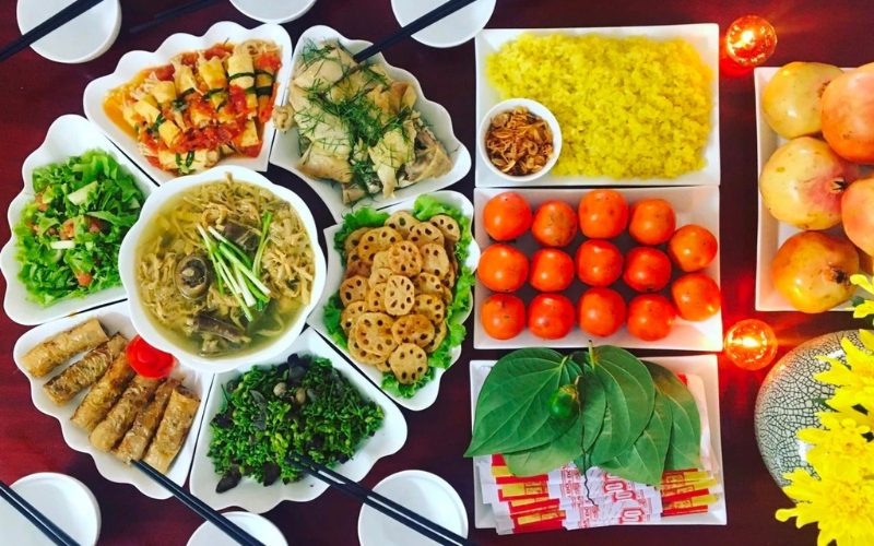 Table d'offrandes traditionnelle pour le rằm tháng 7 au Vietnam, composée de plats faits maison, de fruits, de fleurs, de feuilles de bétel et d'argent votif, soigneusement disposés pour honorer les ancêtres