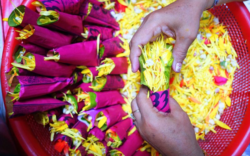 Papier rouge enveloppé de pétales de fleurs fraîches - un cadeau de bénédiction pour les visiteurs du temple