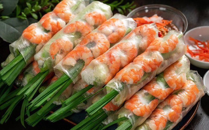 Assiette de rouleaux de printemps vietnamiens (gỏi cuốn) garnis de crevettes, vermicelles, herbes fraîches et ciboulette, servis avec sauces et accompagnements
