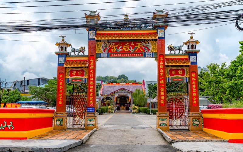 Entrée colorée et ornée de sculptures animales du sanctuaire chinois Sam Pai Kong à Phuket, avec un portail rouge et jaune décoré d’inscriptions chinoises et d’éléments traditionnels