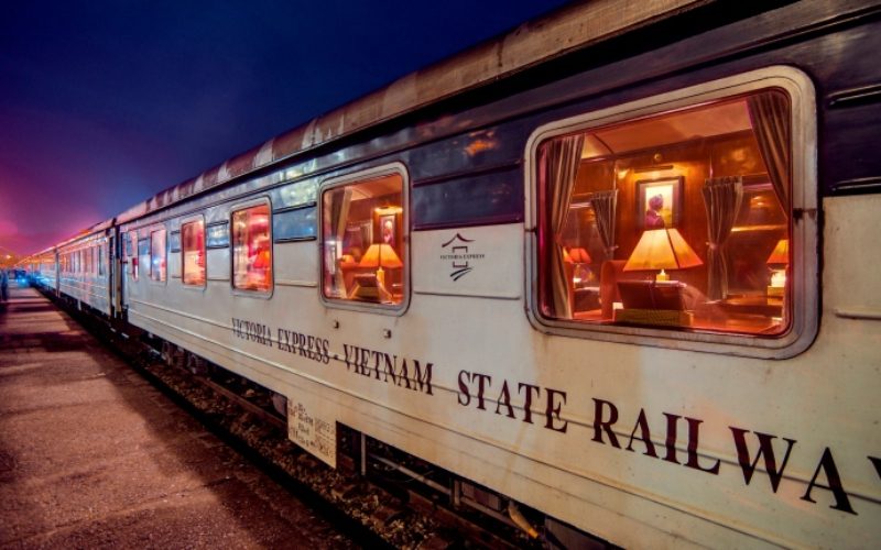 Wagon de nuit luxueux du train Victoria Express au Vietnam, éclairé chaleureusement, prêt pour le départ en soirée