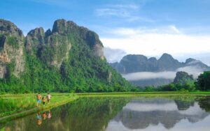 Randonnée à travers des rizières verdoyantes au pied de majestueuses montagnes calcaires à Vang Vieng