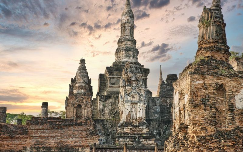 Ruines de temples en briques du parc historique de Sukhothai au coucher du soleil, illustrant l’architecture sacrée de l’ancienne capitale thaïlandaise