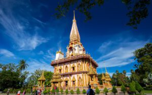 Temple Wat Chalong à Phuket, célèbre pour son architecture dorée et ses détails richement ornés, sous un ciel bleu éclatant