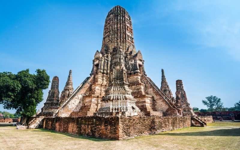 Vue magnifique du temple Wat Chaiwatthanaram à Ayutthaya, Thaïlande, avec son architecture majestueuse en briques rouges et ses tours élancées sous un ciel bleu éclatant